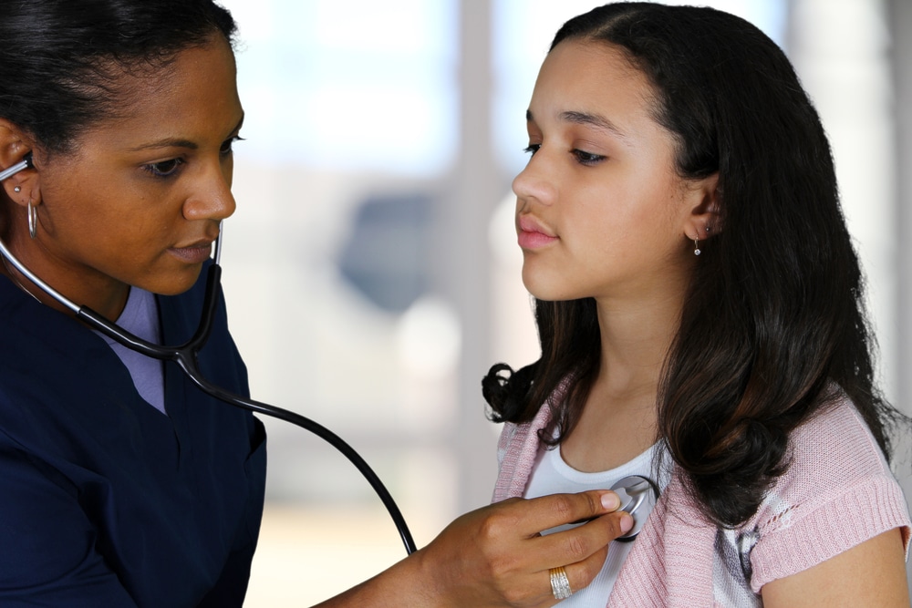 Nurse assisting patient during a college physical exam in a hospital setting. Nurse assisting patient during a college physical exam in a hospital setting.